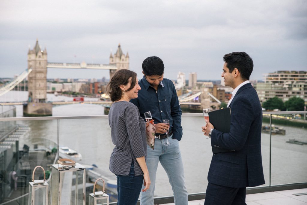 ludzie z drinkami na tle tower bridge w londynie