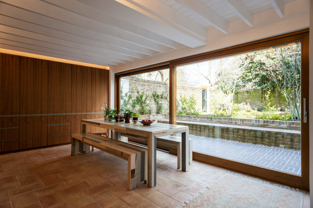 large dining area with a wooden table and a large window in a london house